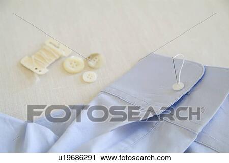 Sewing button on shirt View Large Photo Image Stock Image - Sewing button on shirt. Fotosearch