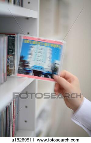 A woman selecting a CD from bookshelf, blurred motion View Large Photo Image Stock Image - A woman selecting a CD from bookshelf, blurred motion. Fotosearch