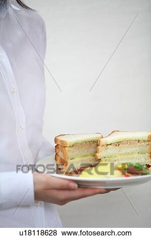 A young woman carrying sandwiches on plate View Large Photo Image Stock Photo - A young woman carrying sandwiches on plate. Fotosearch