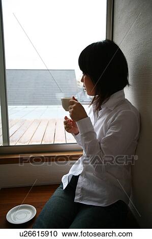 A young woman drinking a cup of coffee View Large Photo Image Stock Image - A young woman drinking a cup of coffee. Fotosearch