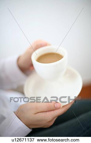 A young woman drinking a cup of coffee View Large Photo Image Stock Photo - A young woman drinking a cup of coffee. Fotosearch