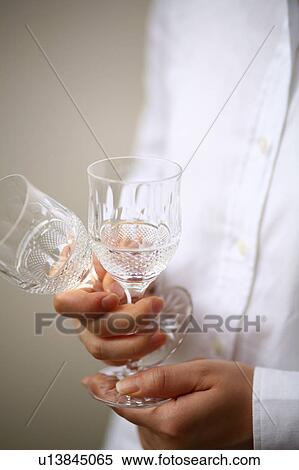 Stock Photography - A young woman holding wineglasses. Fotosearch