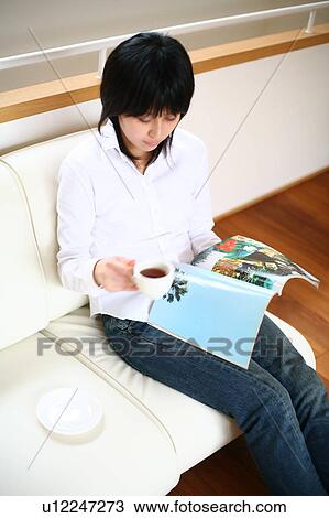 A young woman reading magazine View Large Photo Image Stock Image - A young woman reading magazine. Fotosearch