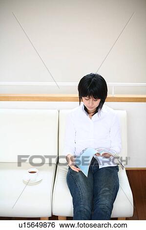 Stock Photograph - A young woman reading magazine. Fotosearch