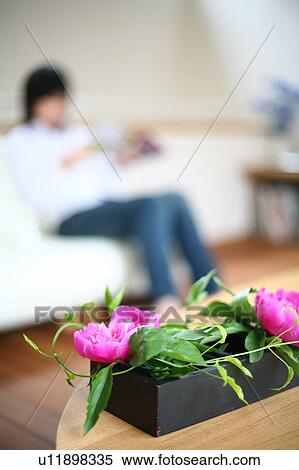 A young woman sitting on sofa View Large Photo Image Stock Photography - A young woman sitting on sofa. Fotosearch