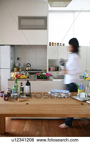 A young woman walking in kitchen, blurred motion View Large Photo Image Stock Photo - A young woman walking in kitchen, blurred motion. Fotosearch