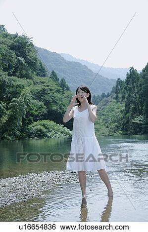 Stock Photograph - A young woman shouting in river. Fotosearch