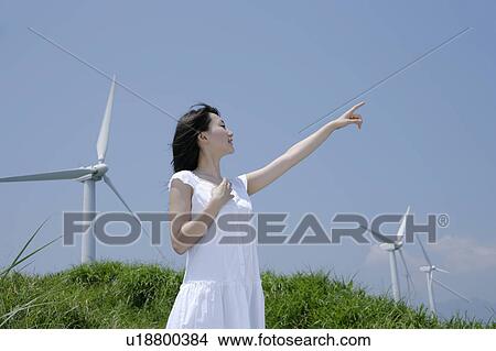 Picture - A young woman standing in field. Fotosearch