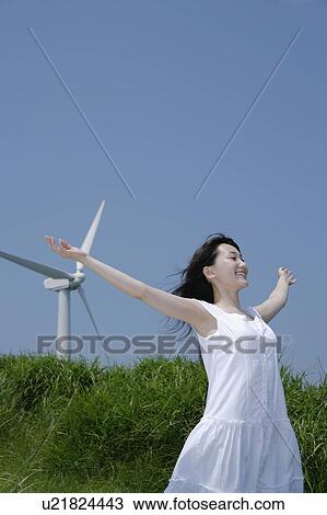 A young woman standing in field View Large Photo Image Stock Image - A young woman standing in field. Fotosearch