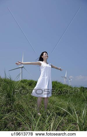 A young woman standing in field View Large Photo Image Stock Photo - A young woman standing in field. Fotosearch