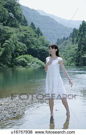 A young woman standing in river View Large Photo Image Stock Photo - A young woman standing in river. Fotosearch