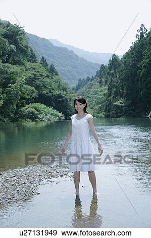 A young woman standing in river View Large Photo Image Stock Photo - A young woman standing in river. Fotosearch