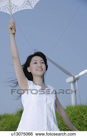 A young woman standing with parasol View Large Photo Image Stock Photograph - A young woman standing with parasol. Fotosearch