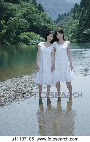 Two young women standing in river View Large Photo Image Stock Photography - Two young women standing in river. Fotosearch