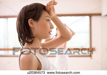 Young woman wiping sweat View Large Photo Image Stock Image - Young woman wiping sweat. Fotosearch