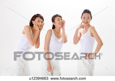 Young women standing side by side View Large Photo Image Stock Image - Young women standing side by side. Fotosearch