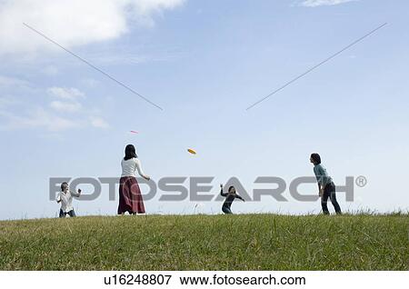 Four young people playing with flying disc View Large Photo Image Stock Photo - Four young people playing with flying disc. Fotosearch