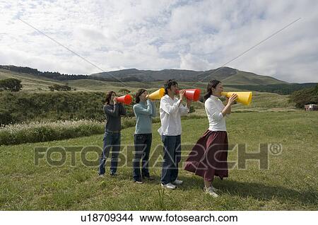 Four young people shouting into megaphones View Large Photo Image Picture - Four young people shouting into megaphones. Fotosearch