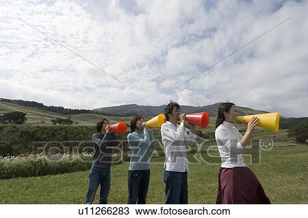 Four young people shouting into megaphones View Large Photo Image Stock Image - Four young people shouting into megaphones. Fotosearch
