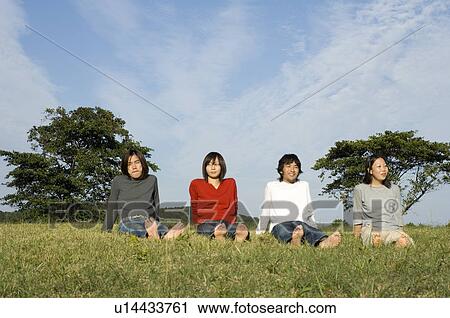 Four young people sitting in field View Large Photo Image Stock Image - Four young people sitting in field. Fotosearch