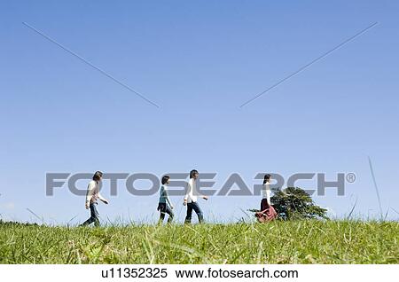 Four young people walking in field View Large Photo Image Stock Photography - Four young people walking in field. Fotosearch