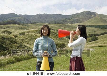 Two young women with megaphones View Large Photo Image Stock Image - Two young women with megaphones. Fotosearch