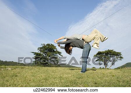 Young couple exercising back to back View Large Photo Image Picture - Young couple exercising back to back. Fotosearch