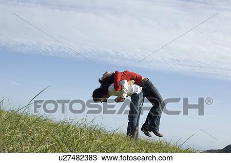 Stock Image - Young couple exercising back to back. Fotosearch
