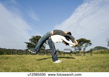 Young couple exercising back to back View Large Photo Image Stock Photography - Young couple exercising back to back. Fotosearch
