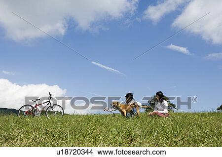 Picture - Young couple playing with dog. Fotosearch