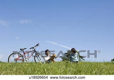 Young couple playing with dog View Large Photo Image Picture - Young couple playing with dog. Fotosearch