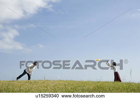 Young couple playing with flying disc View Large Photo Image Stock Image - Young couple playing with flying disc. Fotosearch