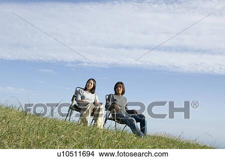 Young couple sitting in chairs View Large Photo Image Picture - Young couple sitting in chairs. Fotosearch