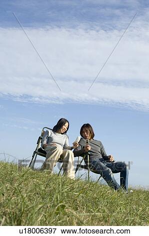 Stock Photo - Young couple sitting in chairs. Fotosearch
