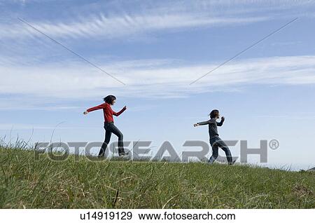 Young couple skipping in field View Large Photo Image Stock Photo - Young couple skipping in field. Fotosearch