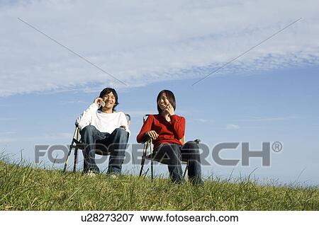 Young couple talking on mobile phones View Large Photo Image Stock Photo - Young couple talking on mobile phones. Fotosearch