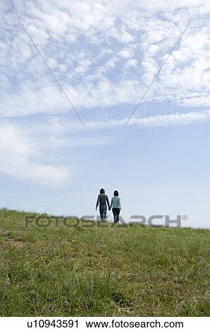 Young couple walking holding hands, rear view View Large Photo Image Stock Image - Young couple walking holding hands, rear view. Fotosearch
