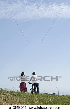 Young couple walking, man pushing bicycle, rear view View Large Photo Image Stock Image - Young couple walking, man pushing bicycle, rear view. Fotosearch