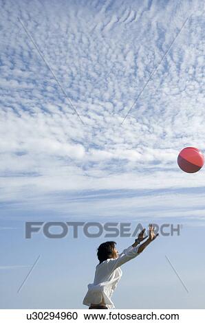 Young man playing with beach ball View Large Photo Image Stock Image - Young man playing with beach ball. Fotosearch