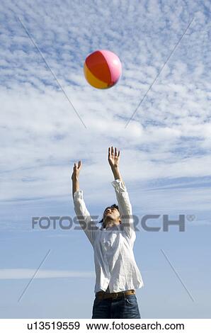 Young man playing with beach ball View Large Photo Image Stock Photo - Young man playing with beach ball. Fotosearch