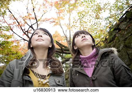 Stock Image - Two young women looking up, Ohara Sanzenin Temple, Kyoto Prefecture, Japan. Fotosearch