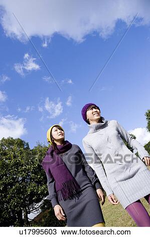 Two young women looking up View Large Photo Image Stock Image - Two young women looking up. Fotosearch