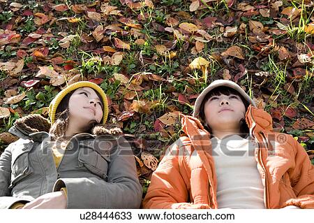 Two young women lying on riverbank View Large Photo Image Stock Image - Two young women lying on riverbank. Fotosearch
