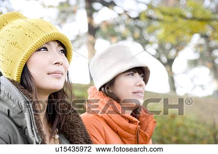 Two young women sitting on riverbank View Large Photo Image Stock Image - Two young women sitting on riverbank. Fotosearch