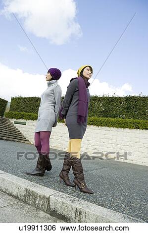 Two young women standing View Large Photo Image Stock Photograph - Two young women standing. Fotosearch