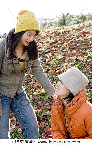 Two young women talking on riverbank View Large Photo Image Stock Photo - Two young women talking on riverbank. Fotosearch