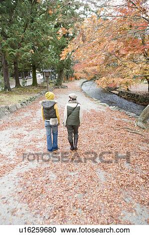 Two young women walking, Kamigamo Shrine, Kyoto Prefecture, Japan View Large Photo Image Stock Image - Two young women walking, Kamigamo Shrine, Kyoto Prefecture, Japan. Fotosearch