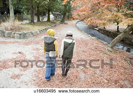 Two young women walking, Kamigamo Shrine, Kyoto Prefecture, Japan View Large Photo Image Stock Photography - Two young women walking, Kamigamo Shrine, Kyoto Prefecture, Japan. Fotosearch