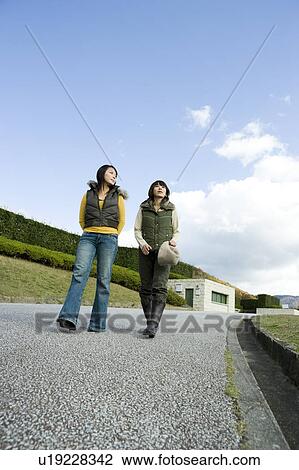 Two young women walking View Large Photo Image Stock Image - Two young women walking. Fotosearch