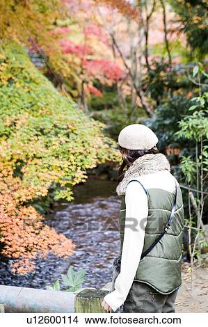 Young woman looking at stream, Kamigamo Shrine, Kyoto Prefecture, Japan View Large Photo Image Picture - Young woman looking at stream, Kamigamo Shrine, Kyoto Prefecture, Japan. Fotosearch